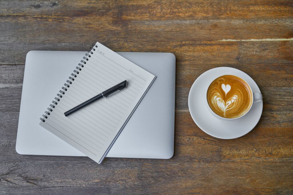 A laptop and coffee on a home desk set up for side work