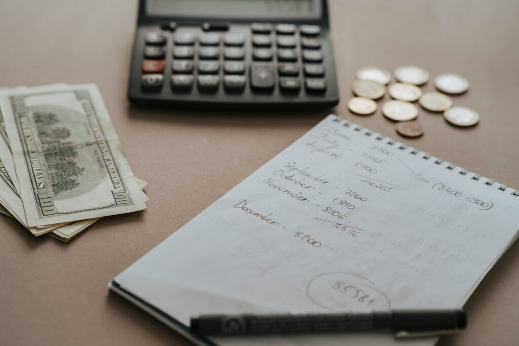 A budget planner, calculator, and pen on a desk