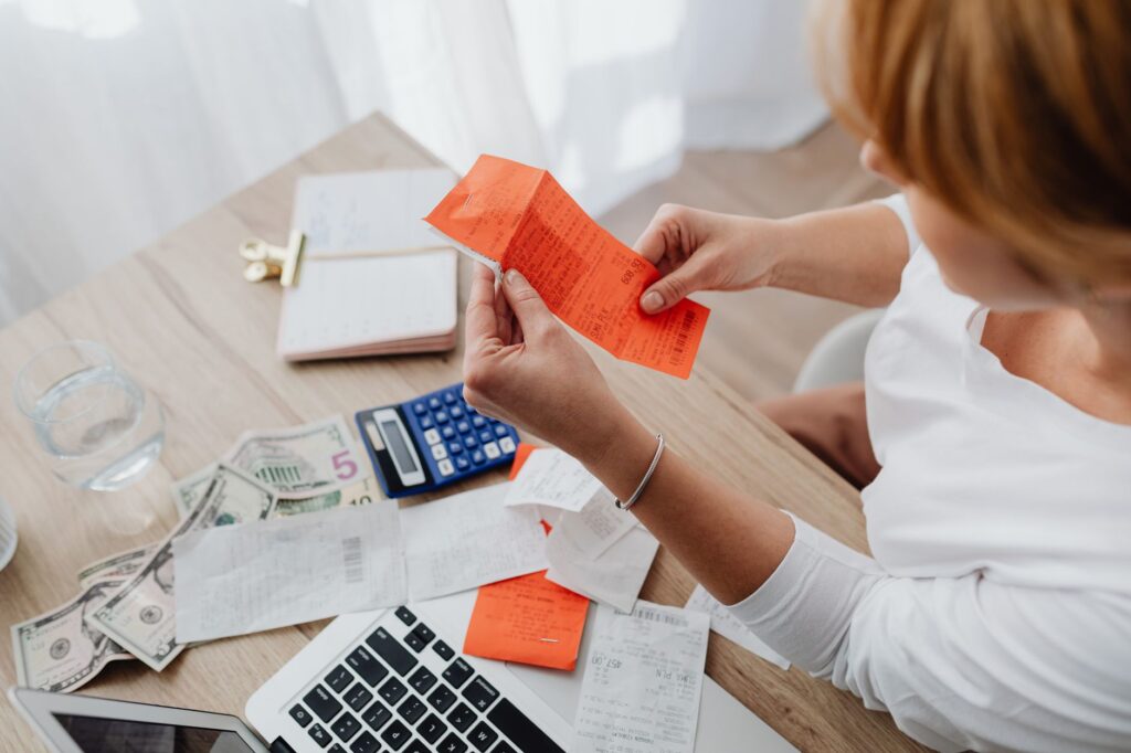 A person reviewing expenses to free up money for debt