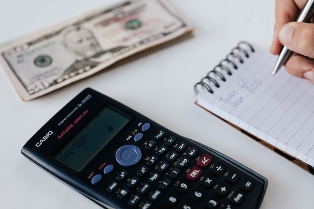 notebook with budget spreadsheet pen and calculator on desk