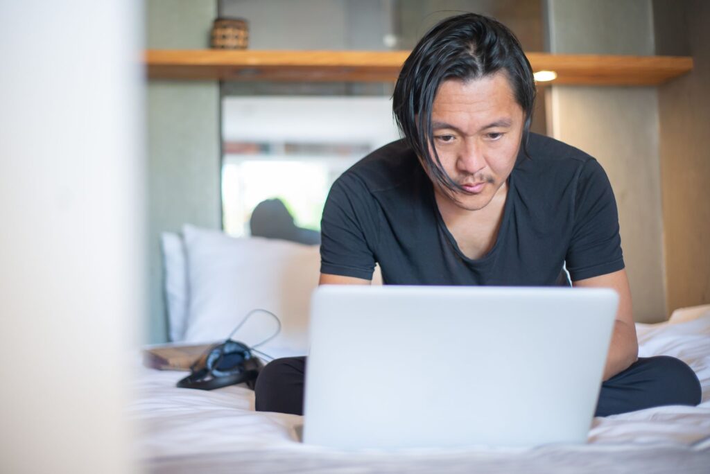 Person working quietly on a laptop at a home desk with coffee