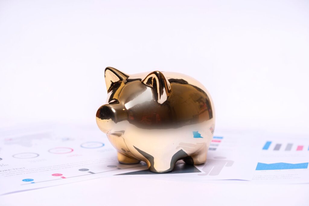 Close-up of a golden piggy bank on financial documents, symbolizing savings and investment.