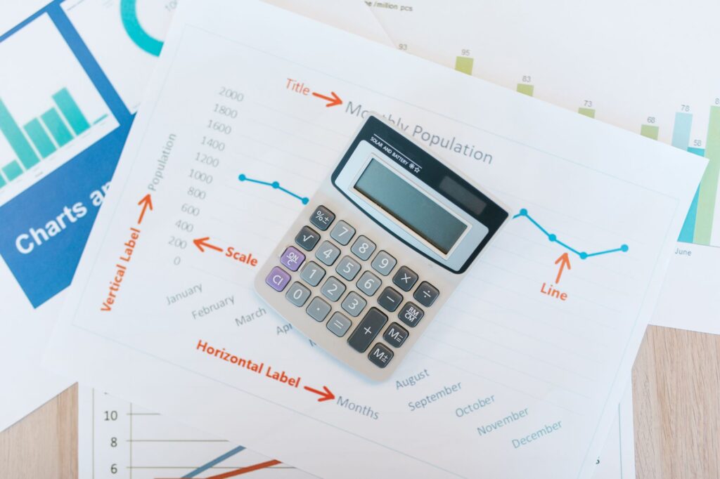Notebook, calculator, and pen used for monthly budget planning