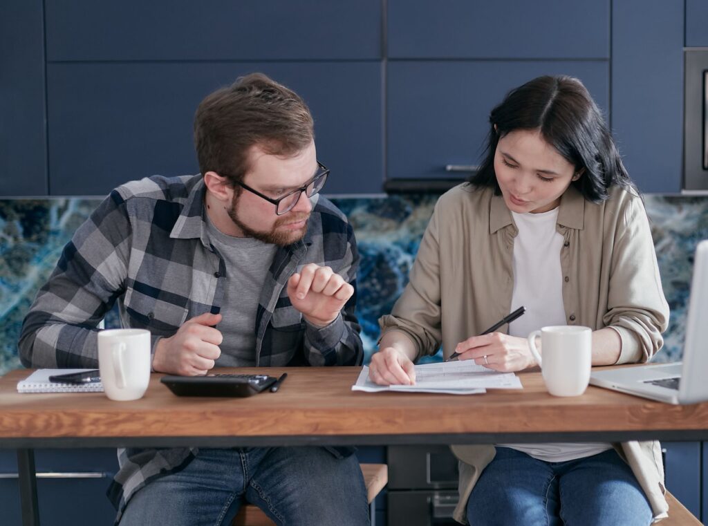 Couple writing down shared financial goals together