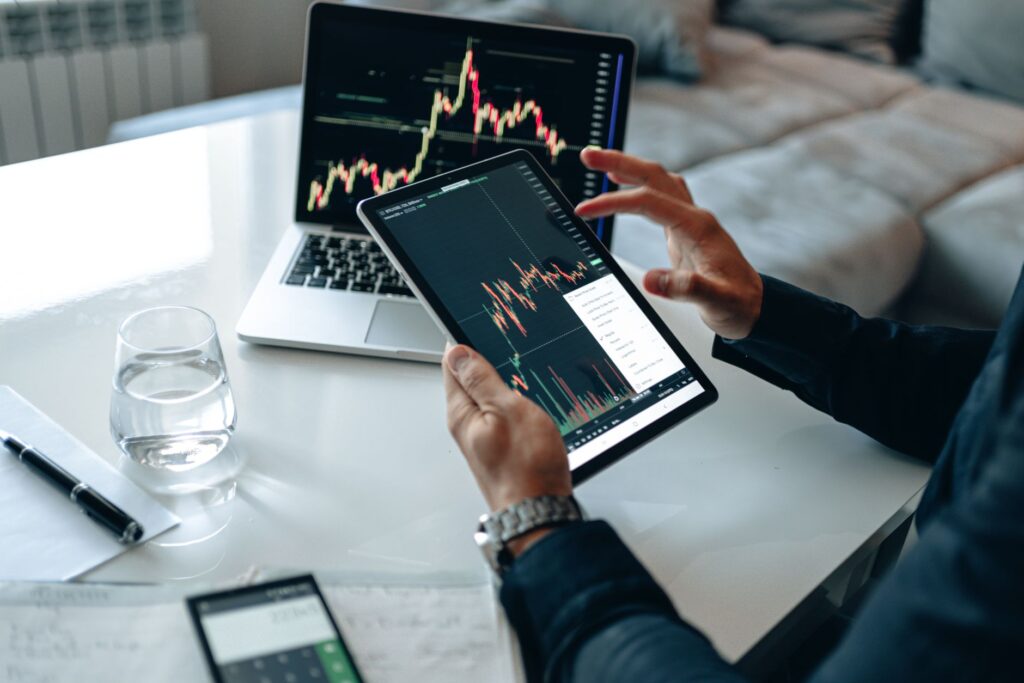Person at a desk comparing bond yields on a laptop next to printed charts