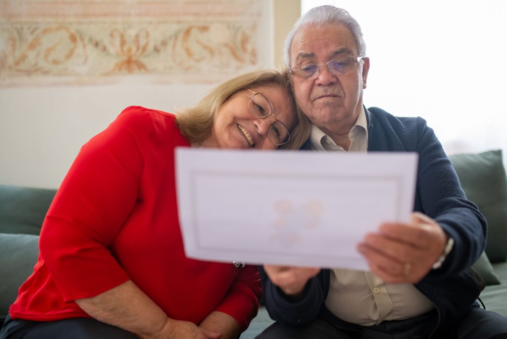 Senior couple sitting at a table reviewing financial paperwork together