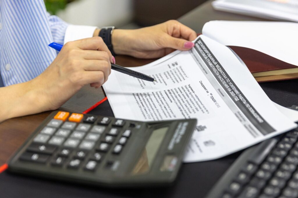 Calculator sitting on top of a retirement account statement on a desk