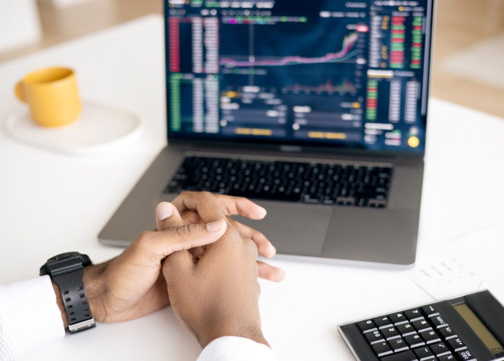 Laptop displaying a stock market chart with an investor reviewing the data