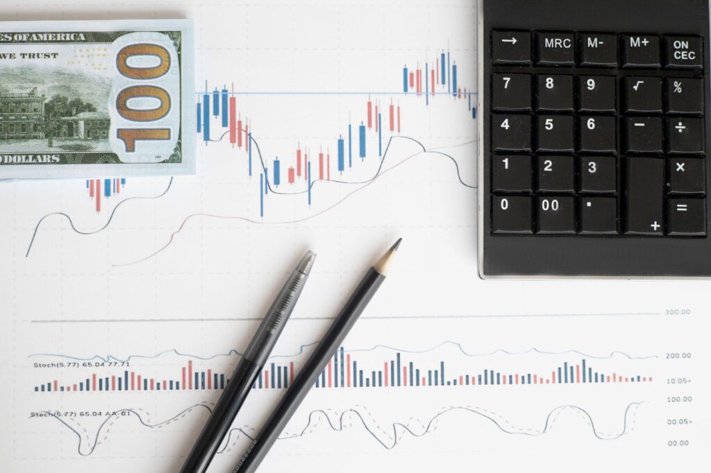 Financial charts, notebook, and calculator laid out for investment planning