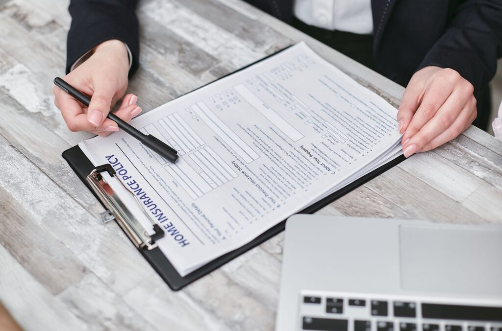 Person reviewing insurance policy paperwork at a kitchen table